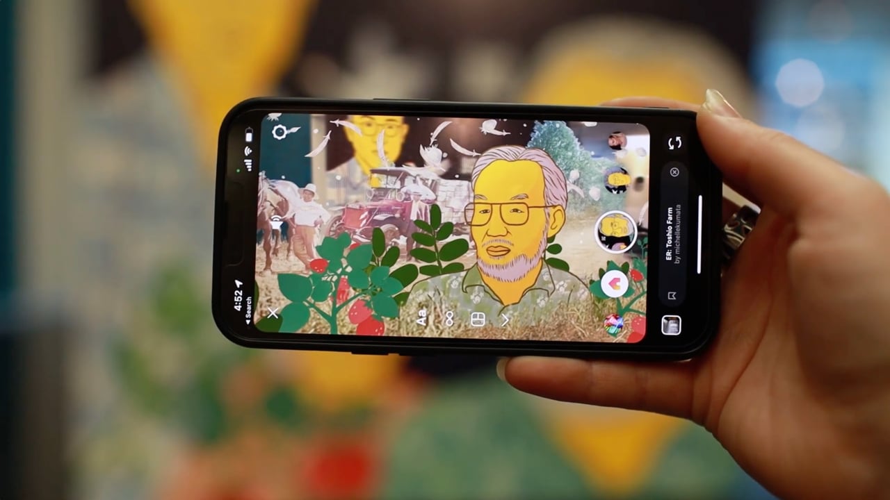 A visitor experiencing Emerging Radiance through augmented reality on a phone