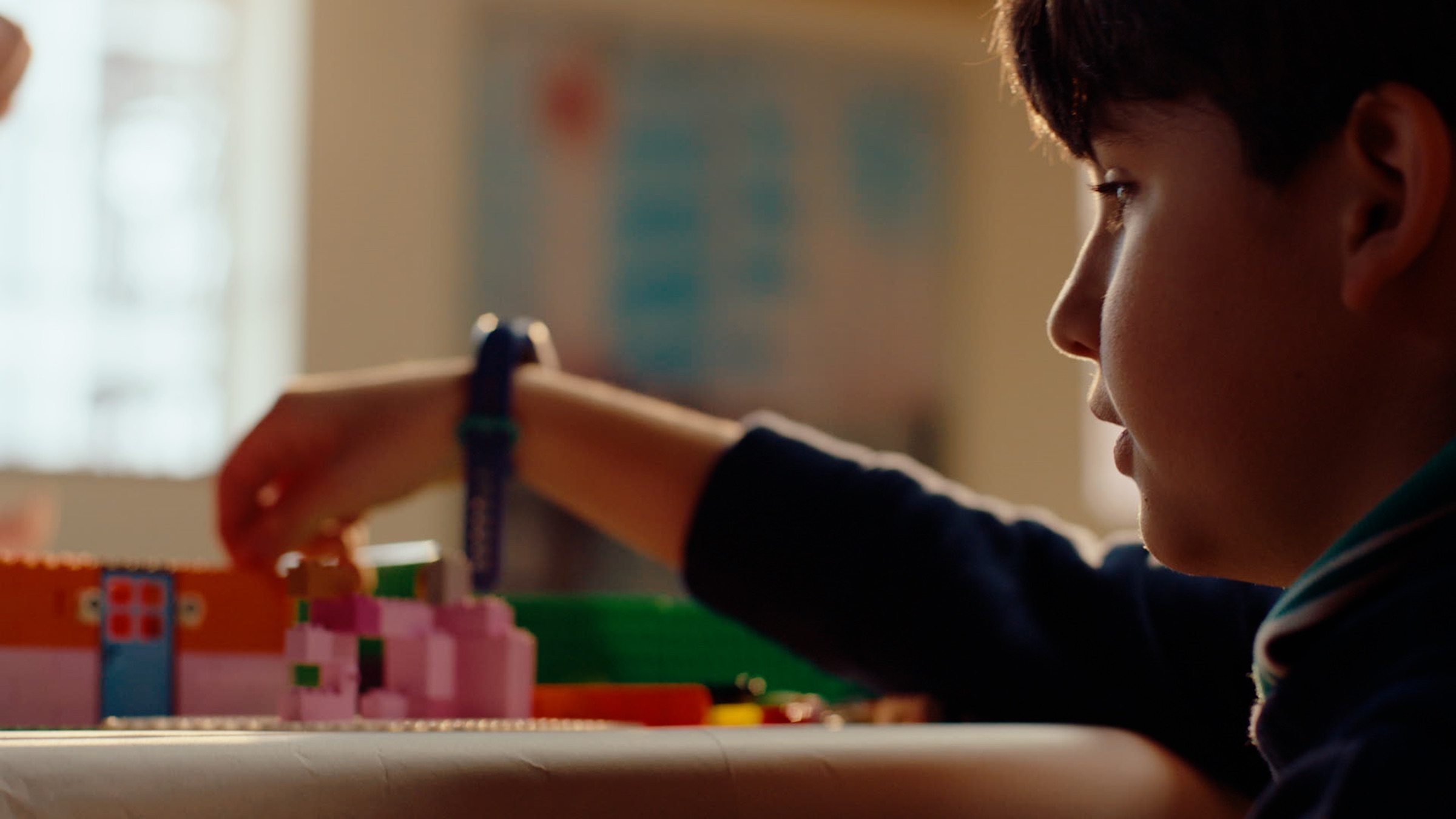 Young participant concentrating on a LEGO brick build