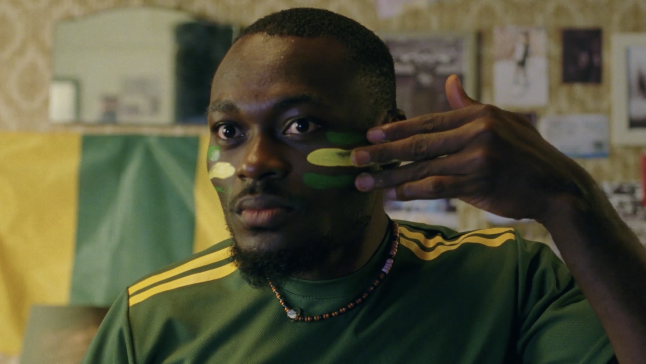 A football supporter applying green and yellow face paint in Kia's Inspire Together campaign