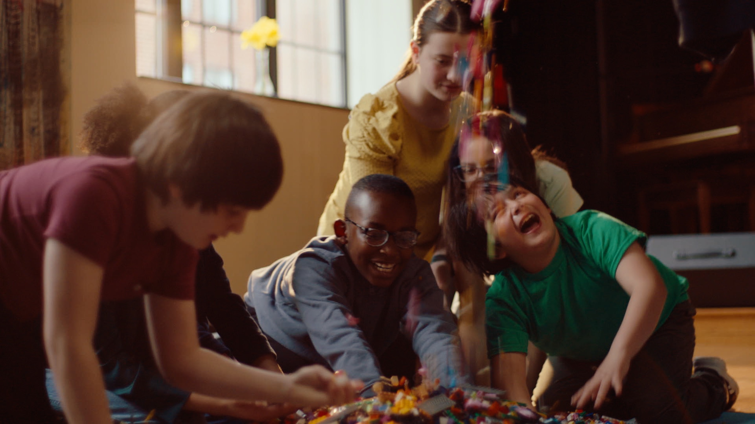 Children laughing and creating together with LEGO bricks